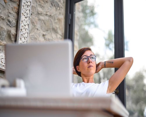 Person taking a break from screen by looking out the window in an office